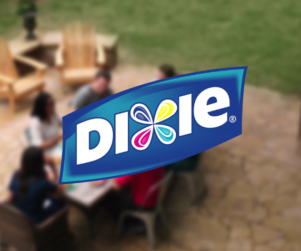 Dixie paper products logo superimposed over a family eating outside in their backyard