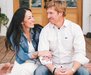 HGTV Fixer Upper hosts Chip and Joanna sitting on a porch smiling